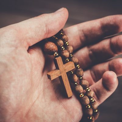 wooden cross in hand with focus on the cross
